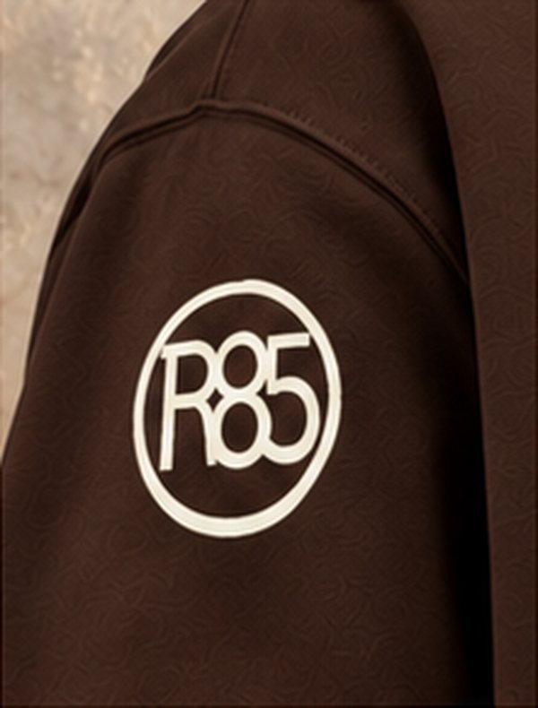 Círculo R85 en la manga de una sudadera café