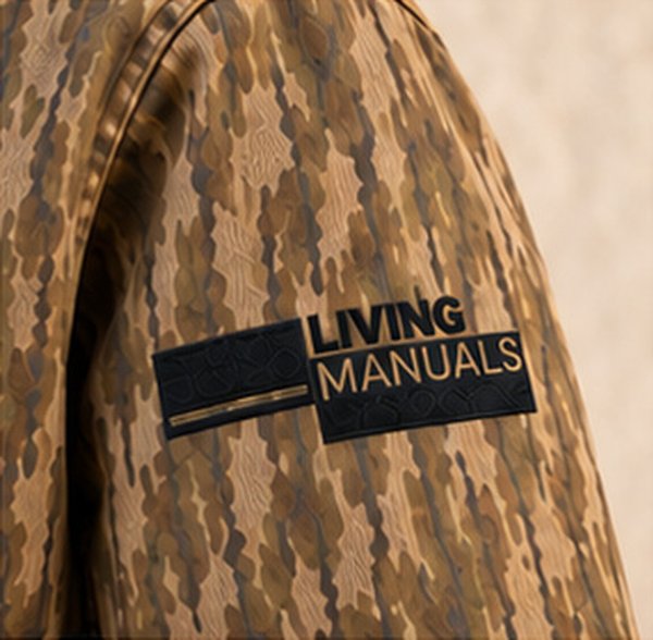 Logotipo de Living Manuals bordado en la manga de una chamarra de camuflaje